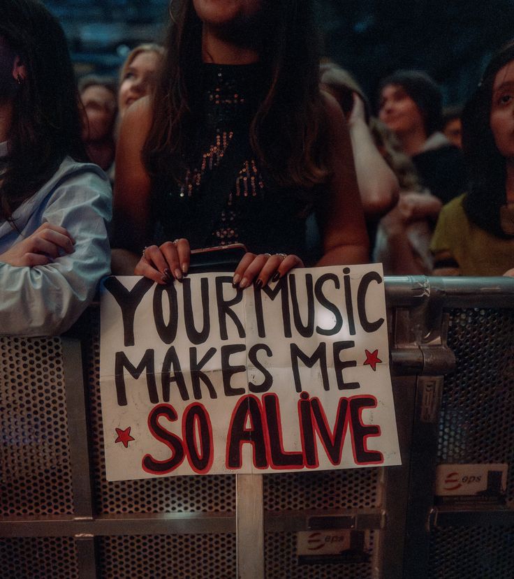  fan holding sign your music makes me alive showing why live concerts are popular