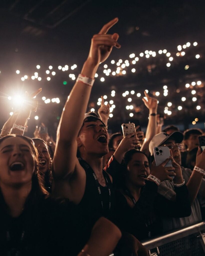  crowd with phone lights showing why live concerts are popular